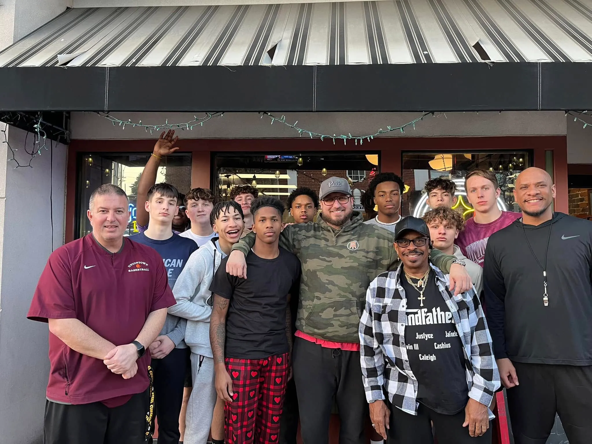 Ben Venick on the steps of Rizz's with a local football team